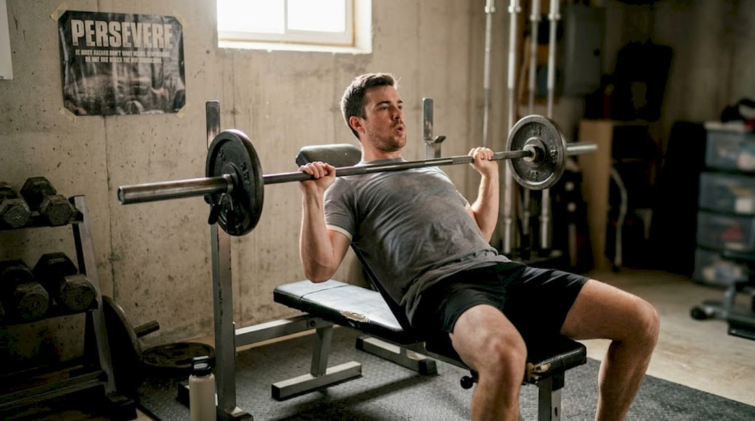 Man bench pressing in home gym setting